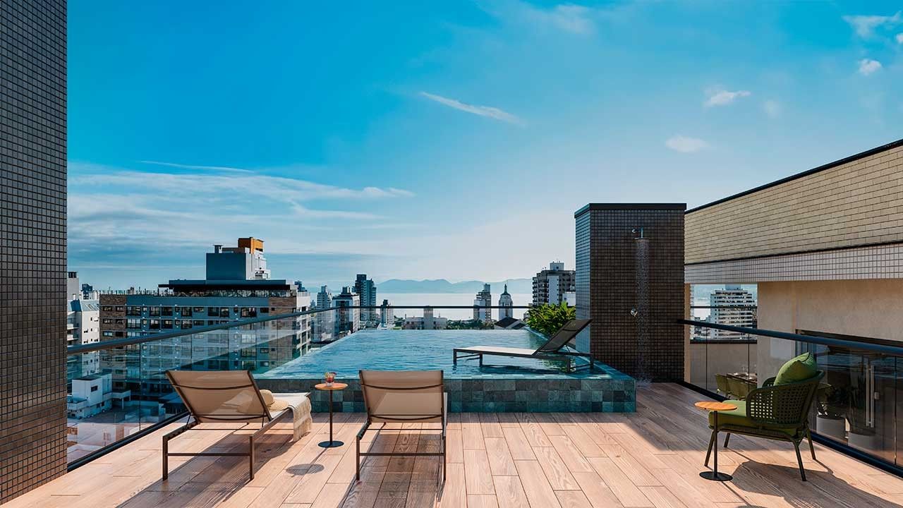 Piscina com borda infinita no rooftop do In Haus Afonso Pena, com vista para Florianópolis